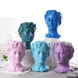 Statues têtes grecques colorées.