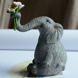Statue éléphant assis avec fleur